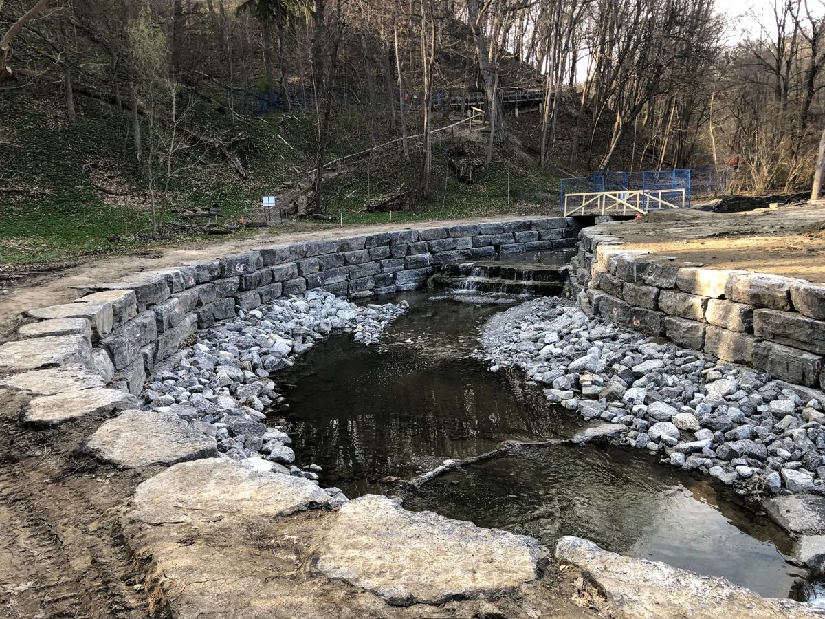 River lined with stone walls and rip-rap.